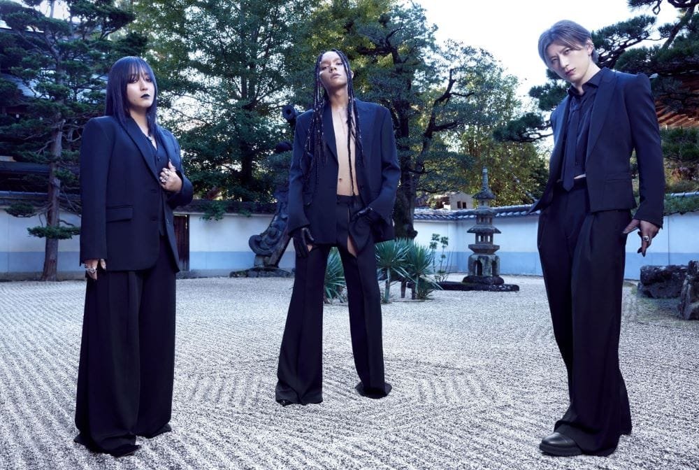 Promotional photo for Queen Bee that depicts the members of the group dressed in black suits