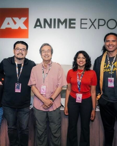 Photograph of the staff members from CAPE as they stand in front of an Anime Expo display